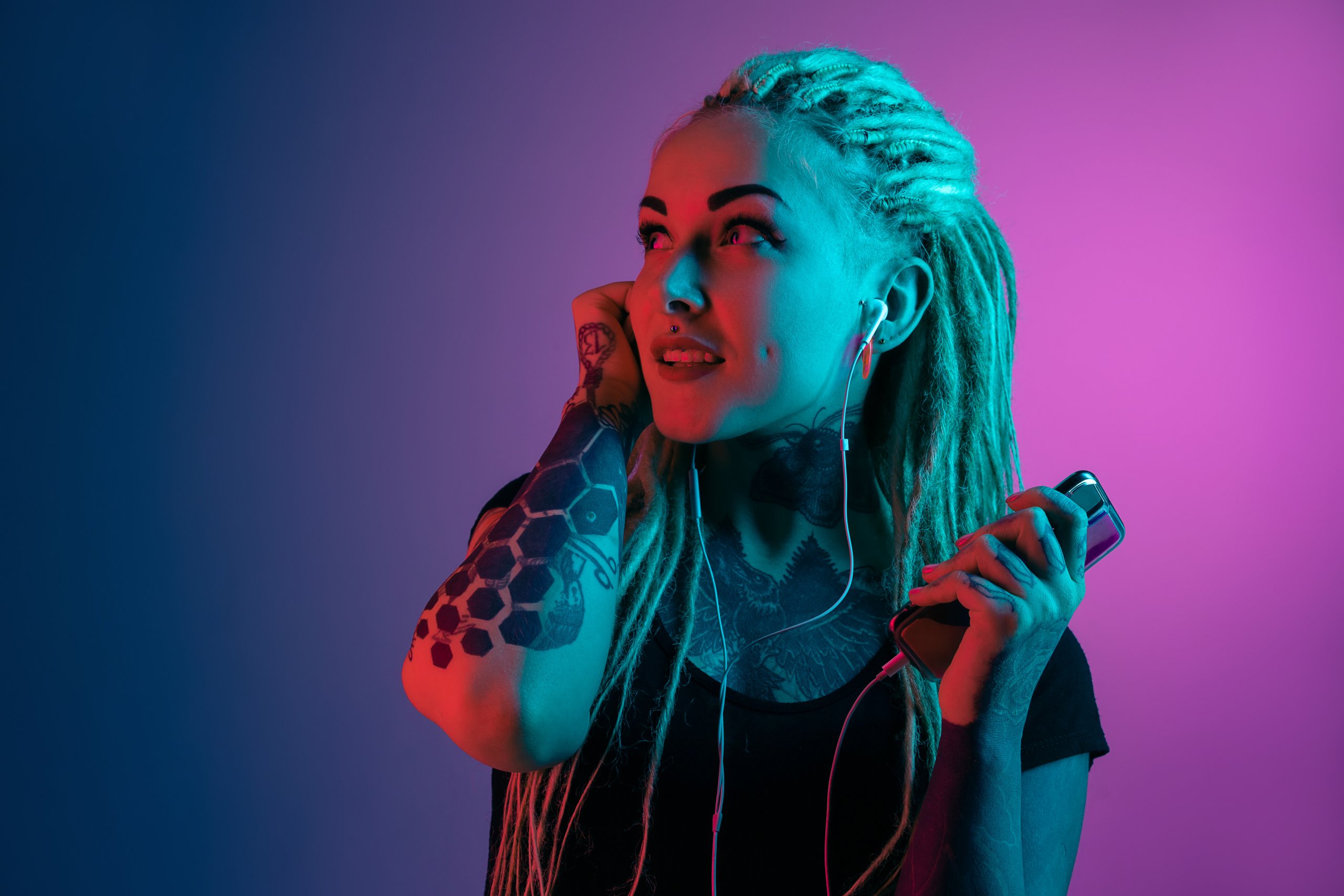 Caucasian young woman's portrait on gradient background in neon light